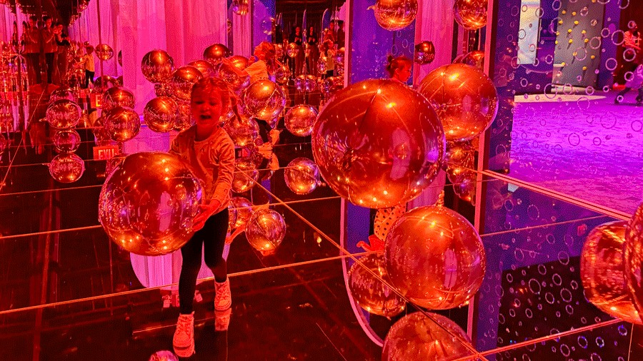 young girl playing with silver balloons at Bubble Planet in Bellevue