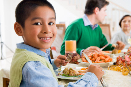 Cute little boy eating a fancy dinner