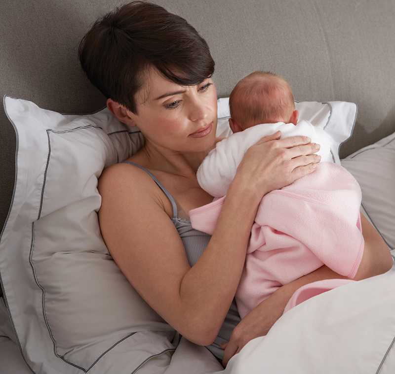 Baby with mom in bed trying to sleep