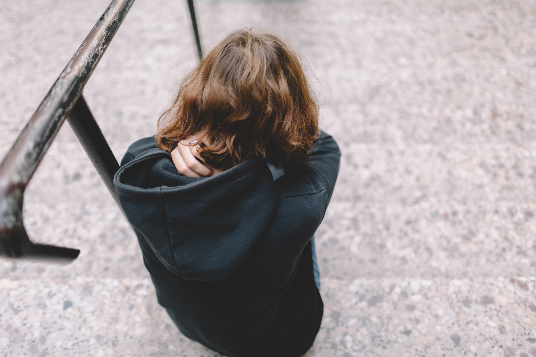 Depressed teenager sitting on stairs