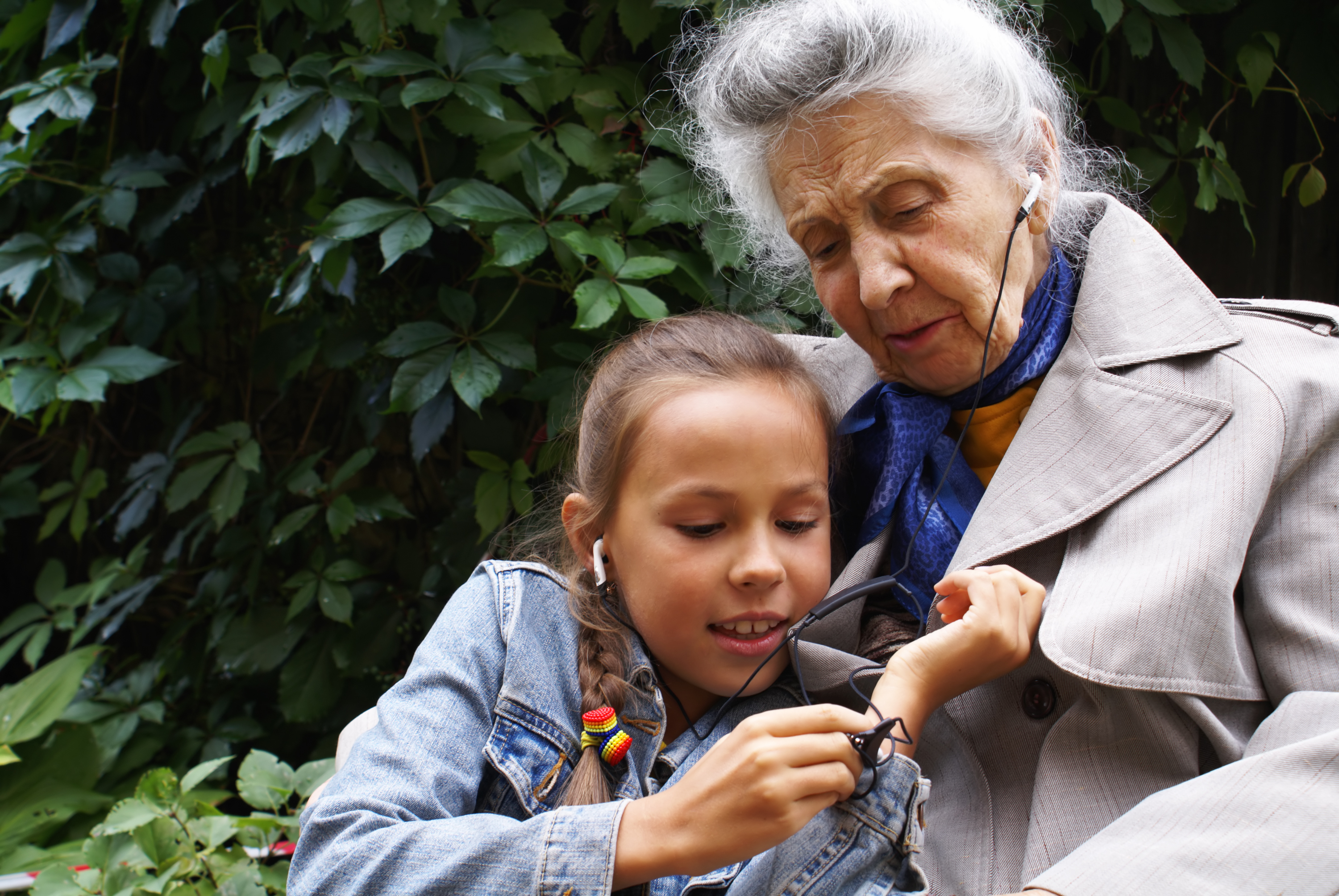 Older woman and young girl listening to a podcast