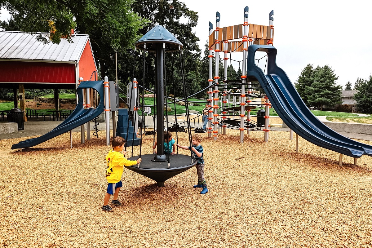 Kids play with the spinner a modern merry-go-round of sorts at the new playground at Kent’s Chestnut Ridge Park