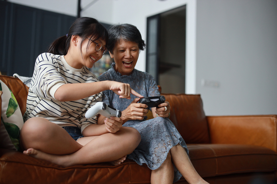 teen girl teaches her mom how to play video games