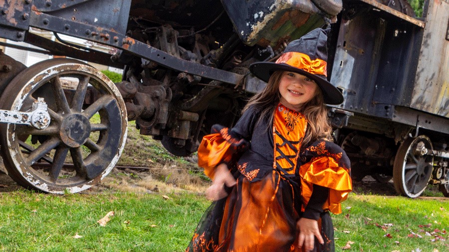 "Young girl in a Halloween costume in front of the Family Halloween Train near Seattle"