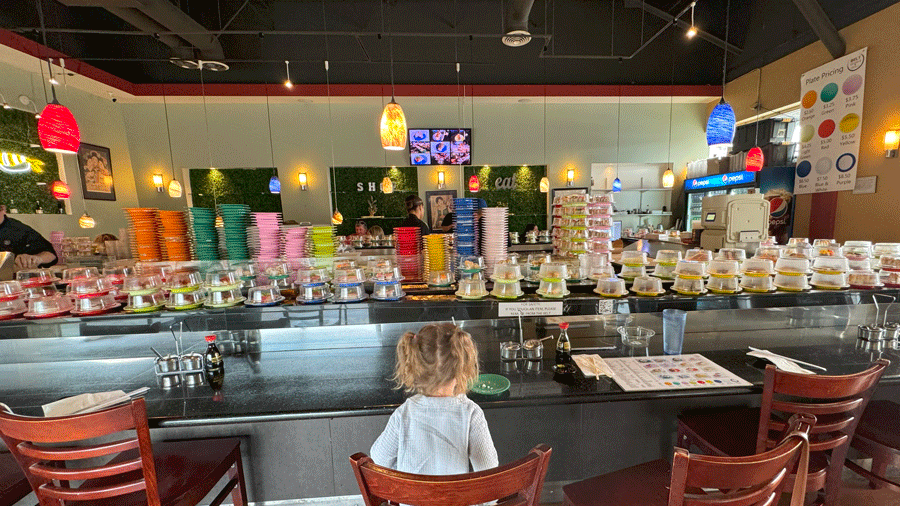 "Stacks of sushi plates rotating on a conveyor belt at Belt Sushi & Roll in Marysville, a Seattle-area sushi restaurant"