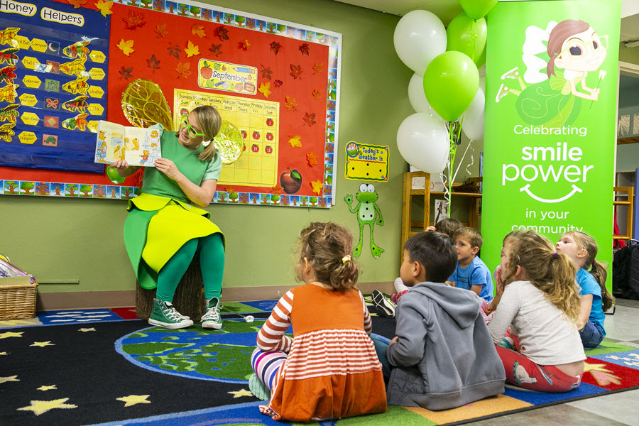 Tooth Fairy reads a book to young children