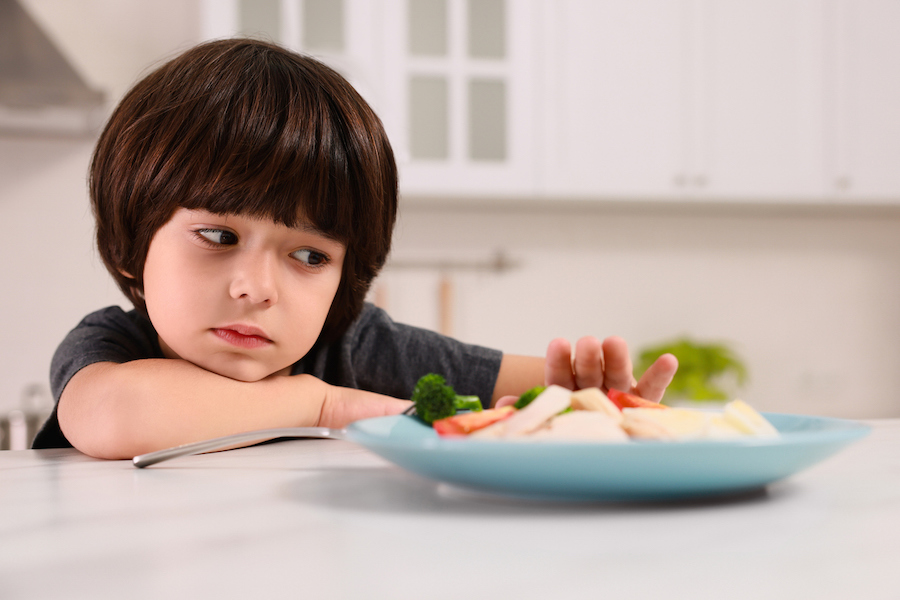 child at dinner resisting the meal