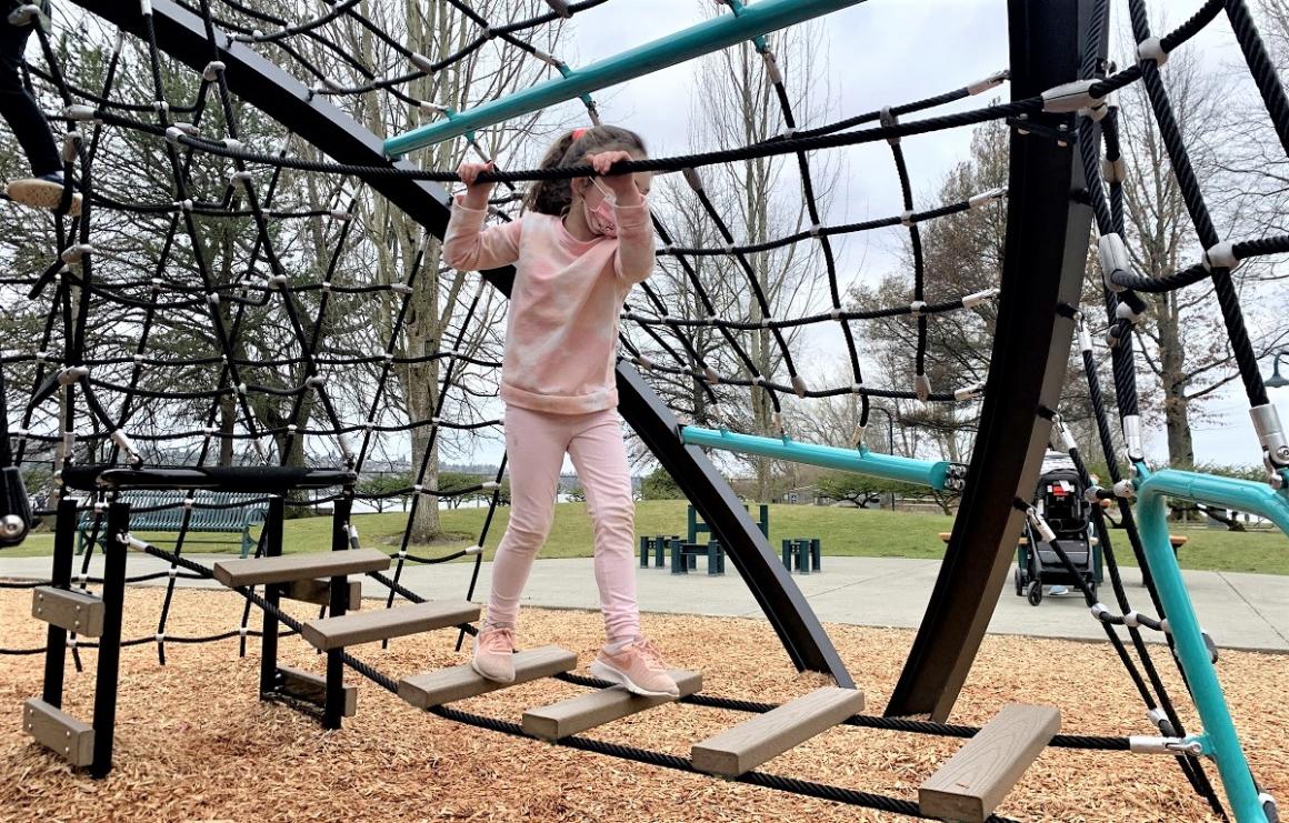 Girl walking on balance elements at new Gene Coulon Memorial Beach Park playground