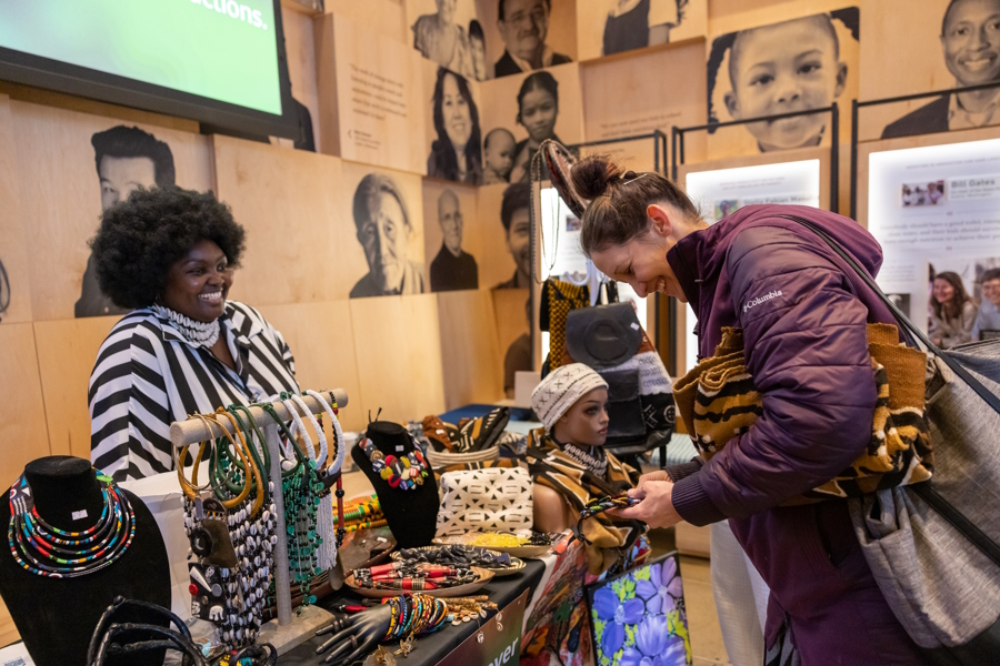 A woman shopping and chatting with a vendor at the Giving Marketplace