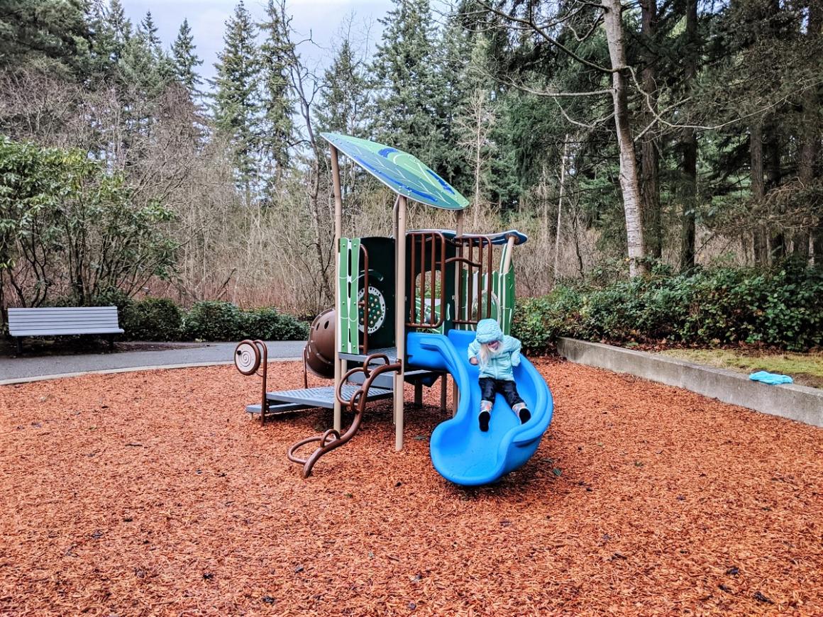 Heron Park blue slide at newly renovated play area girl in blue jacket sliding playing