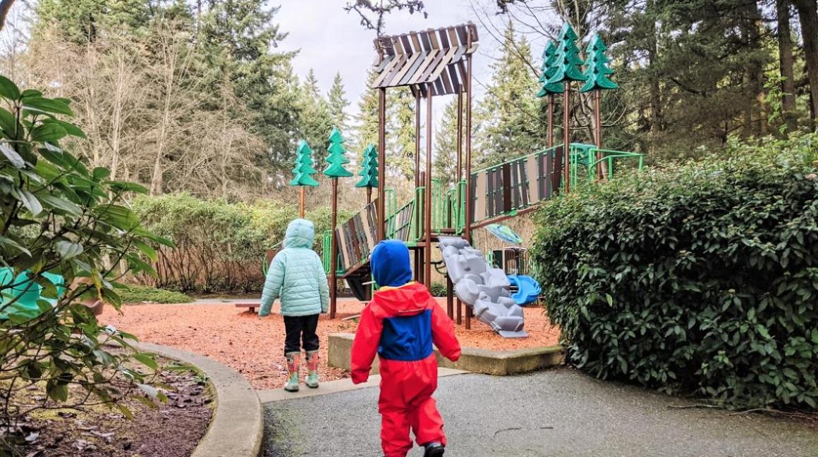 Two kids approach a play structure at Heron Park playground