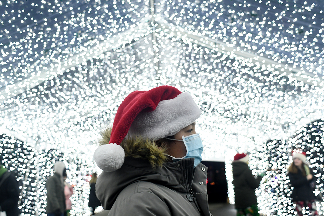 A boy in a santa hat is seen in profile standing under a canopy of lights at Holiday Magic at the Fair in Puyallup a holiday event for Seattle area families