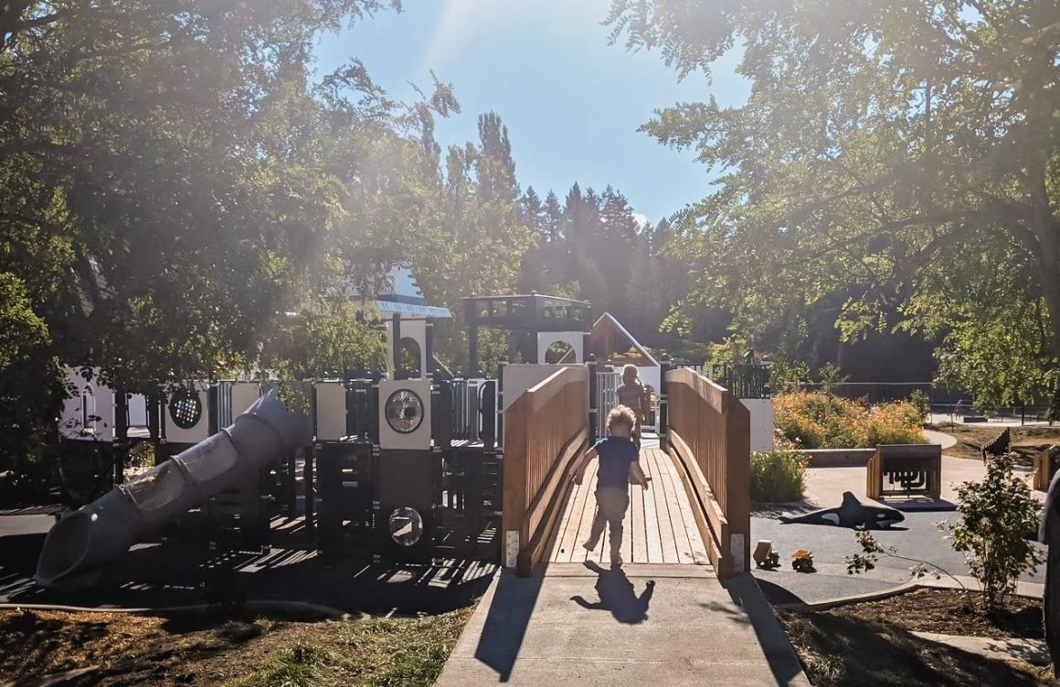 Boy running toward new ferry boat playground on Bainbridge Island near Seattle kids and families