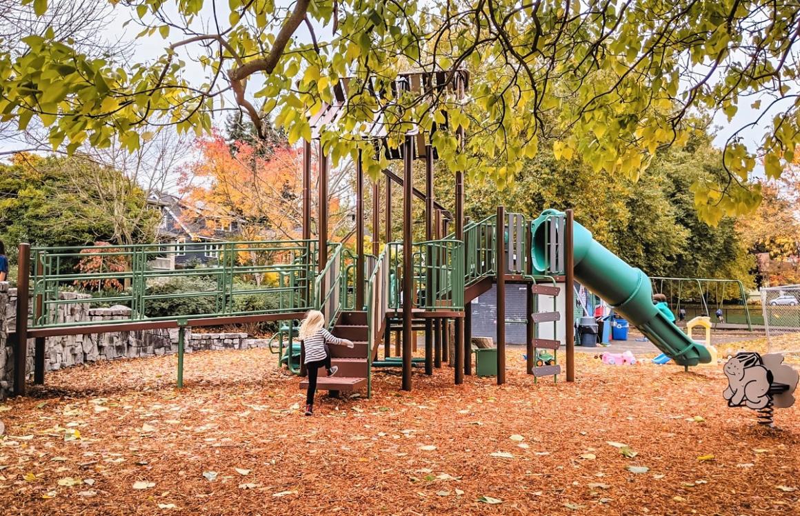 Swings in the distance behind new play structure at Lakewood Playground update South Seattle neighborhood park