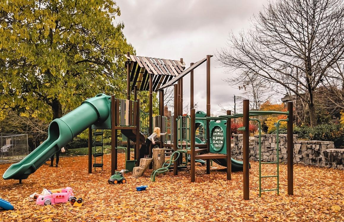 A young girl in a striped shirt climbs on new play equipment at updated Lakewood Playground in South Seattle new playspot for Seattle kids and families