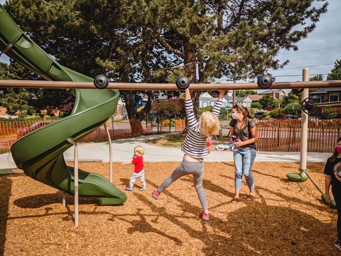 Girl on monkey bars playing at new Loyal Heights Playfield playground opened June 2021