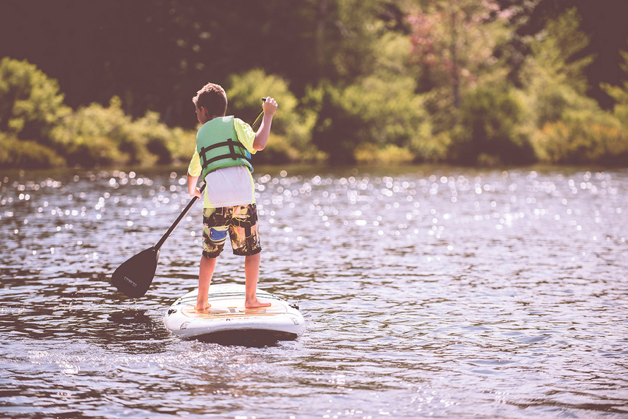 little boy paddleboarding