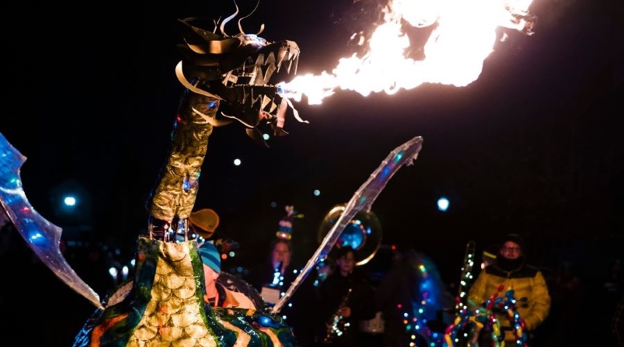 A fire-breathing dragon kicks off Tacoma’s Light Trail parade.