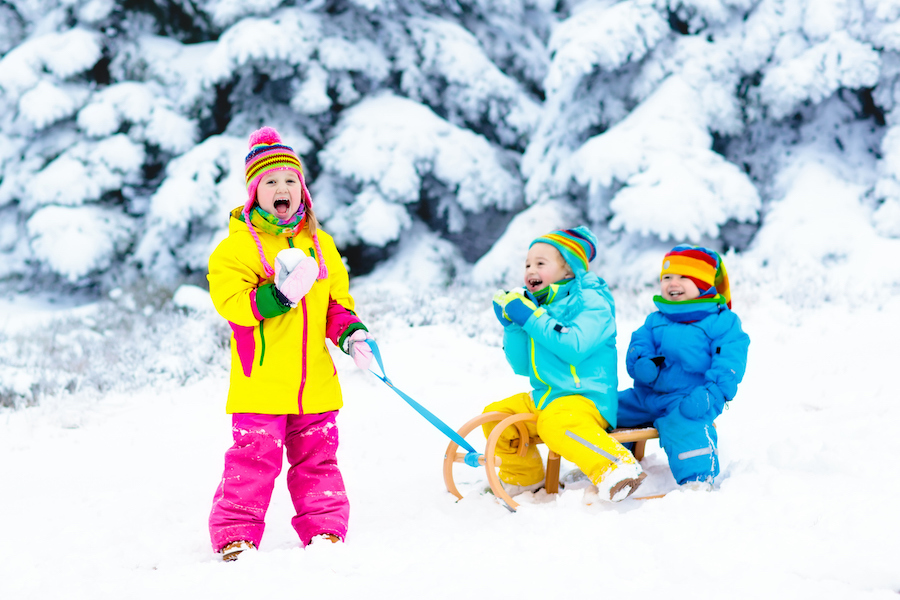 children play and laugh in the snow for a fun and natural holiday photo