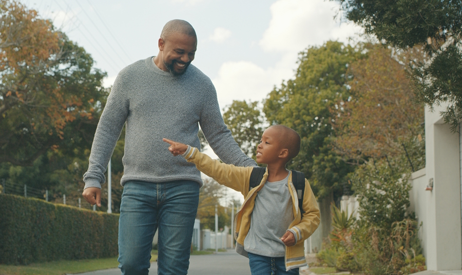 dad and son walking in a neighborhood 