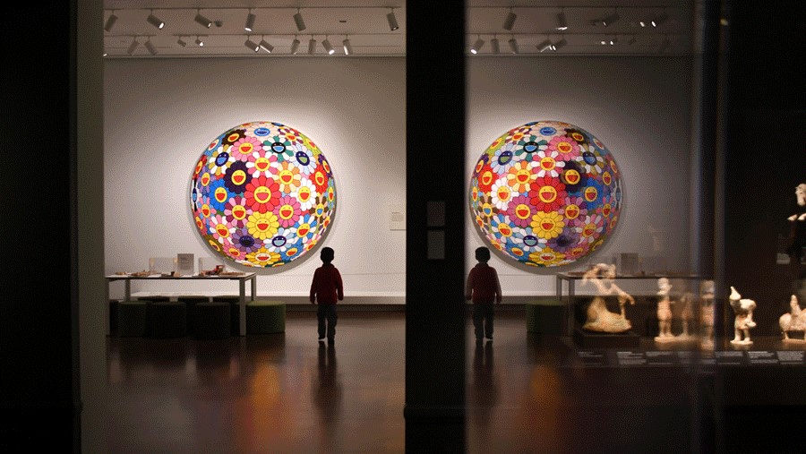 young boy walking in Seattle Asian Art Museum with a bright flower artwork display, a museum that participates in Free First Thursdays