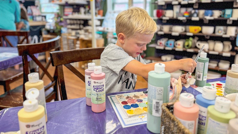 Young boy painting pottery at Glazed and Amazed, a Seattle-area indoor activity for families