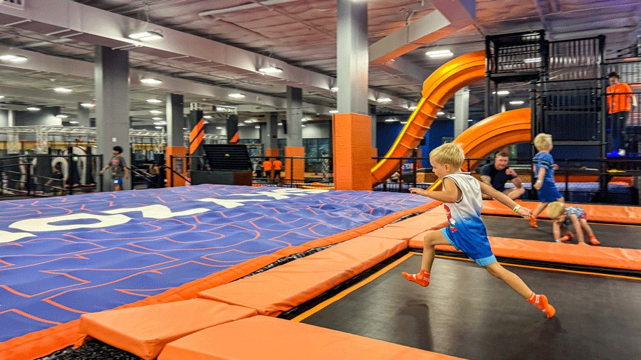 young boy running across trampoline at skyzone trampoline park near Seattle, an indoor activity for kids