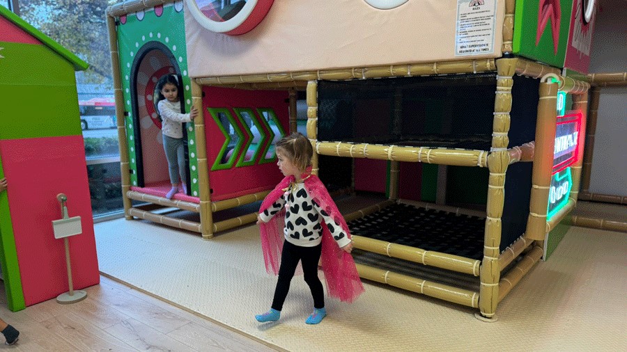 young girl wearing sparkly dress-up cape at Little Pandas Play Cafe