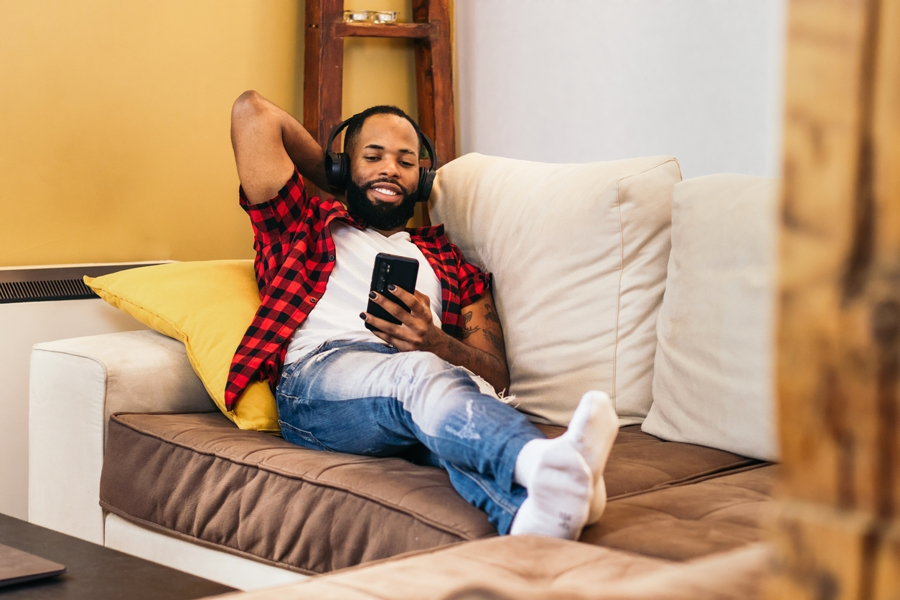 man on couch listening to a parenting podcast