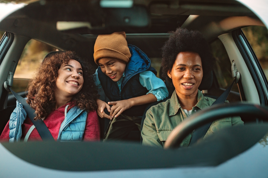 moms and a kid in a car heading off for an adventure