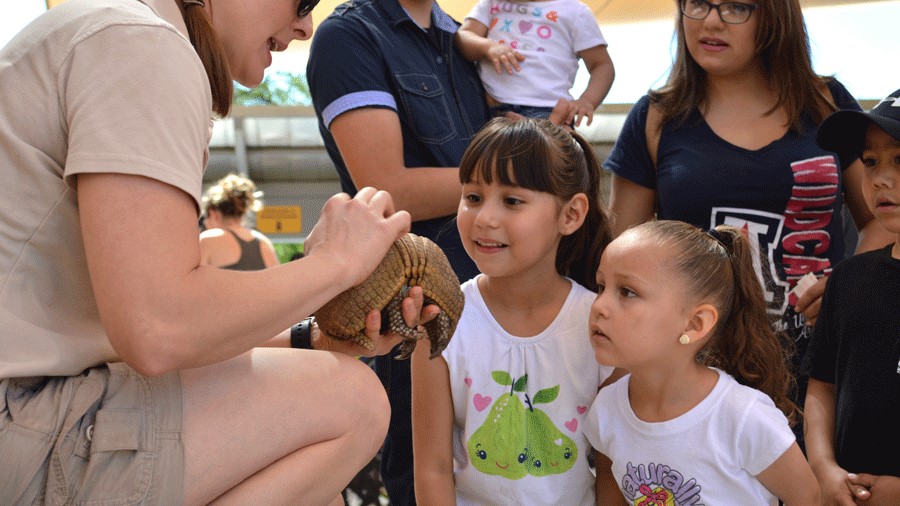 kids learning about animals from a zookeeper at the Phoenix Zoo, a fun family activity for warm winter vacations