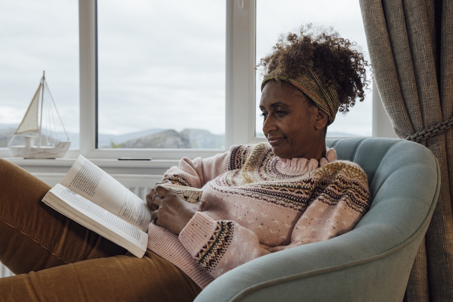 woman by a window reading