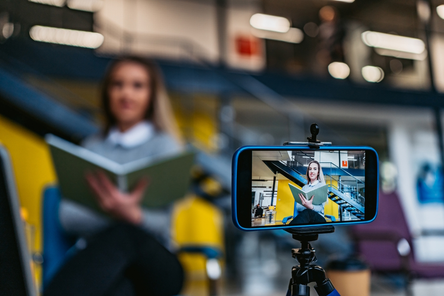 woman recording herself reading a book