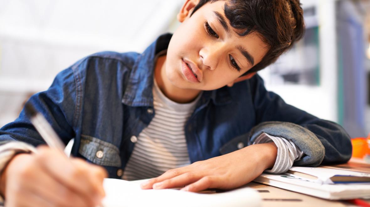 boy writing in a notebook