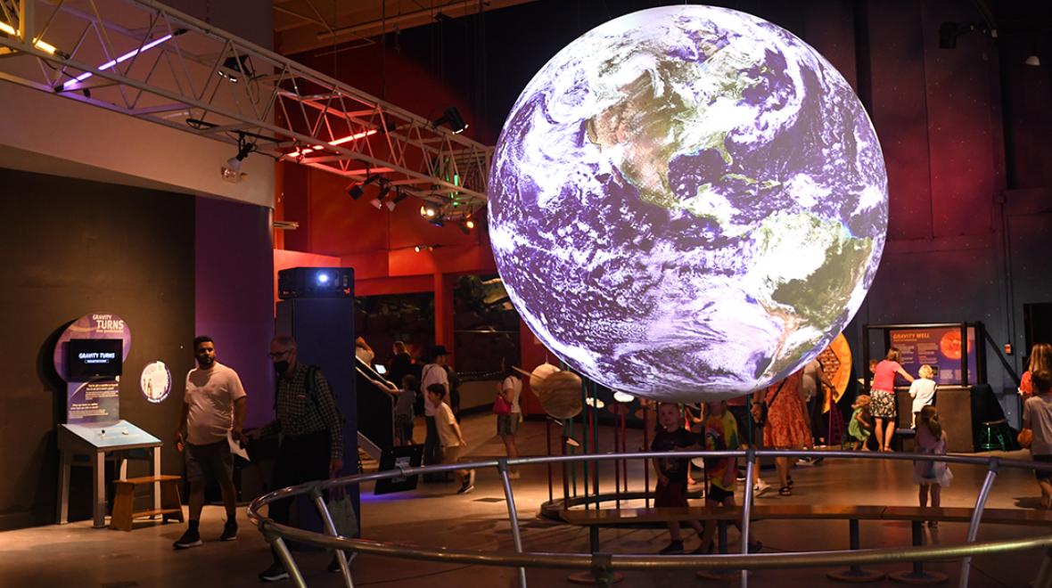 Kids look at science exhibits at Seattle's reopened Pacific Science Center among indoor play spaces for families during poor air quality